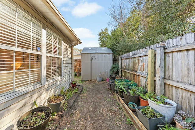 view of yard with an outbuilding, a shed, a fenced backyard, and a vegetable garden