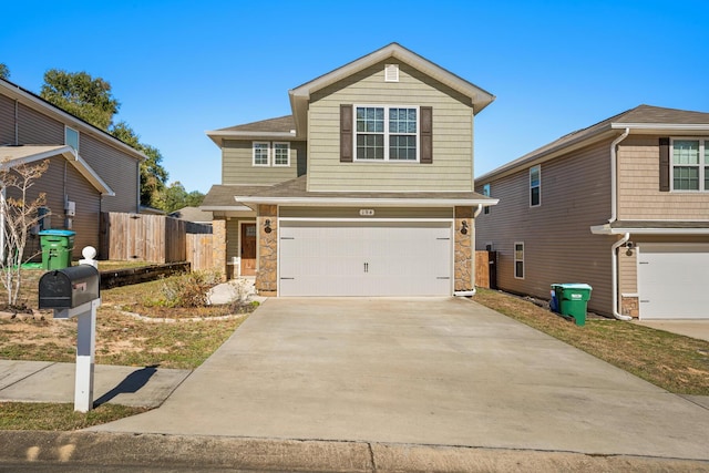 view of front of home with stone siding, fence, driveway, and an attached garage