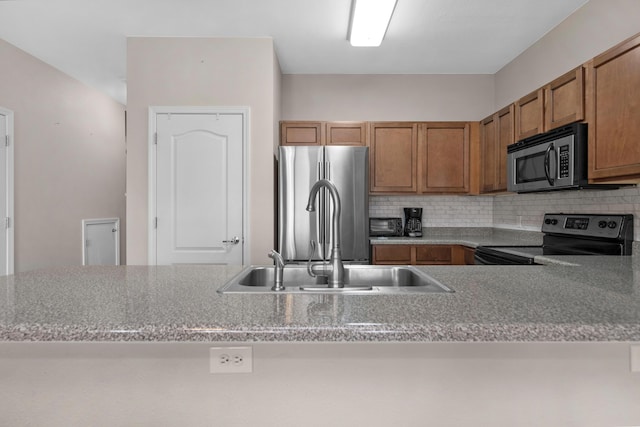 178 E Iron Horse Dr, Crestview, FL 32539 - kitchen with appliances with stainless steel finishes, brown cabinetry, a sink, and decorative backsplash