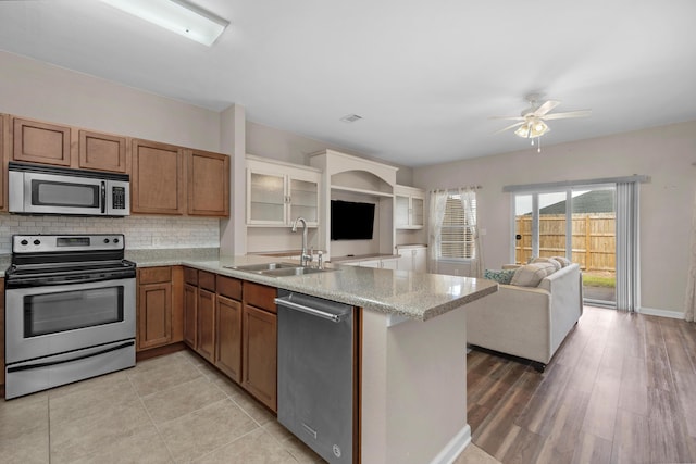 178 E Iron Horse Dr, Crestview, FL 32539 - kitchen with tasteful backsplash, open floor plan, a peninsula, stainless steel appliances, and a sink