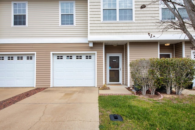 multi unit property featuring an attached garage and concrete driveway