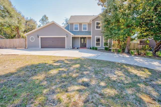 view of front facade with concrete driveway, an attached garage, fence, and a front lawn