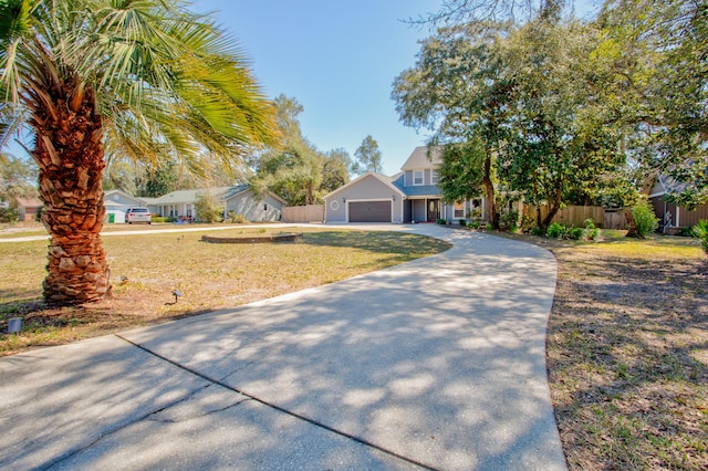 view of front of home featuring a front yard, an attached garage, fence, and driveway