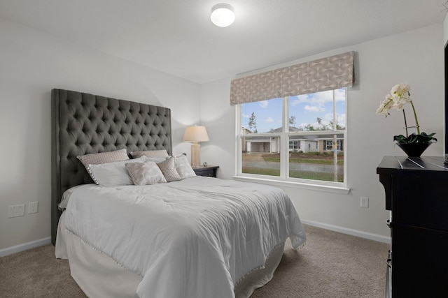 bedroom featuring light carpet and baseboards