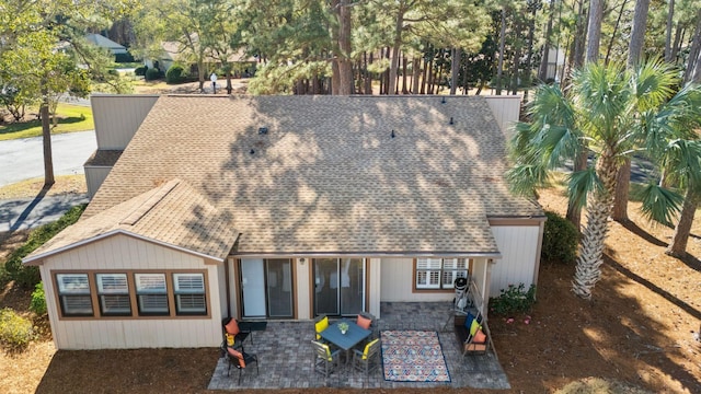 view of front of property with a shingled roof and a patio area