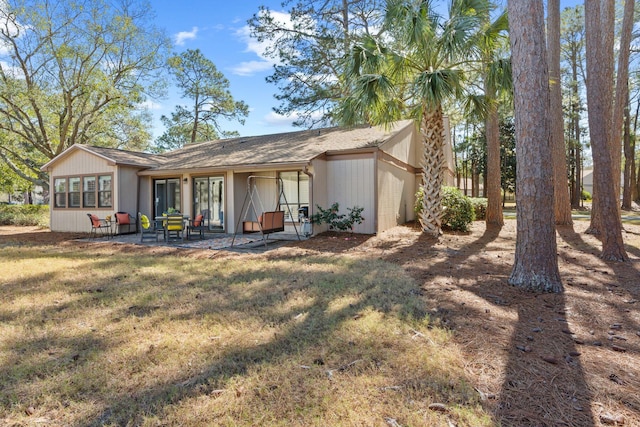 back of house with a patio area, a lawn, and a garage