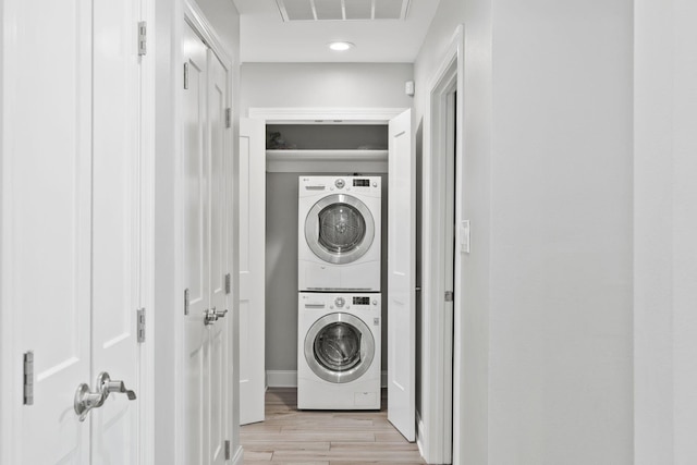 laundry room featuring stacked washer / dryer, light wood-style flooring, laundry area, and visible vents