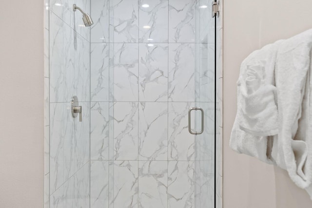 full bathroom featuring a marble finish shower