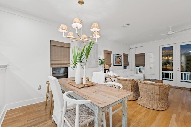 dining area with baseboards, visible vents, ornamental molding, wood finished floors, and french doors