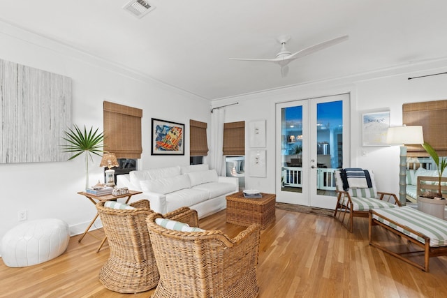 living room featuring ceiling fan, wood finished floors, visible vents, french doors, and crown molding