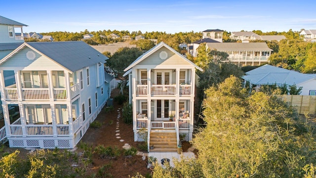 rear view of property with stairway, a residential view, french doors, and a balcony