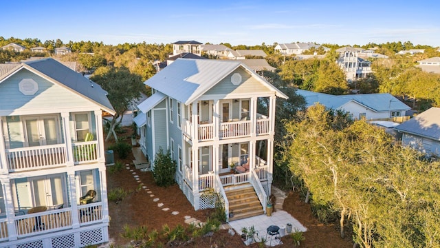 rear view of property with a balcony, covered porch, and a residential view