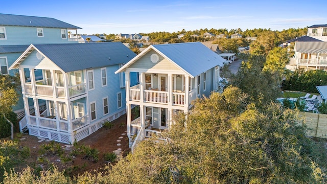 rear view of property featuring metal roof, a residential view, and a balcony