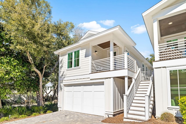 view of front of home featuring a garage, driveway, and stairway