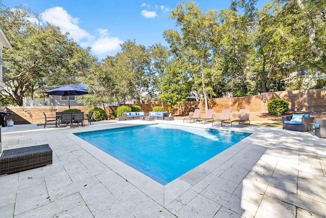 view of swimming pool with a fenced in pool, a patio area, a fenced backyard, and an outdoor living space