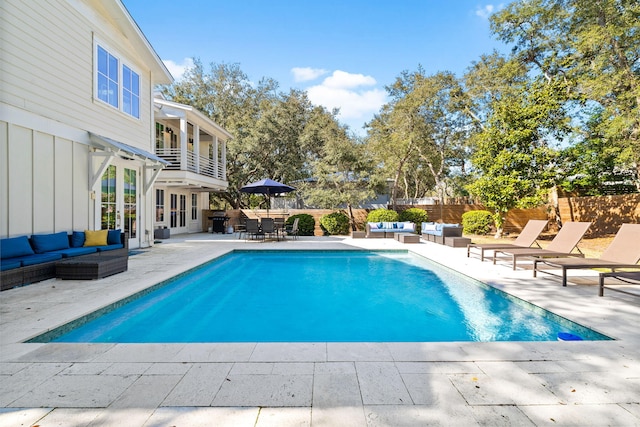 view of pool with a fenced in pool, a patio area, a fenced backyard, and an outdoor living space