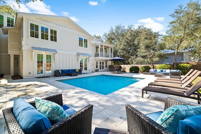 outdoor pool featuring an outdoor living space, a patio, and french doors