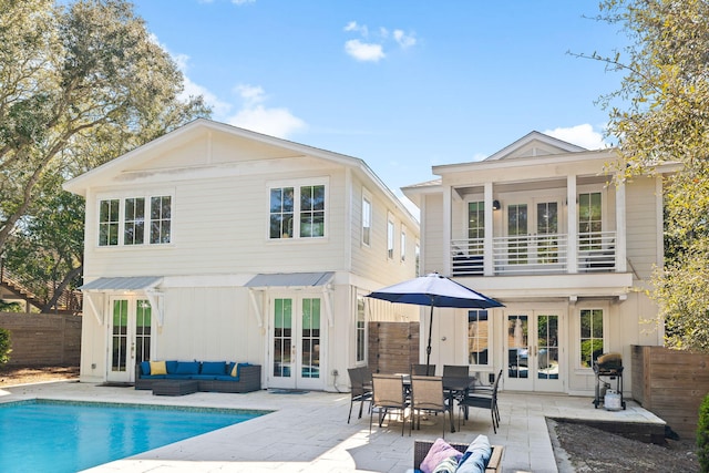 back of property featuring a patio, a balcony, fence, french doors, and outdoor lounge area