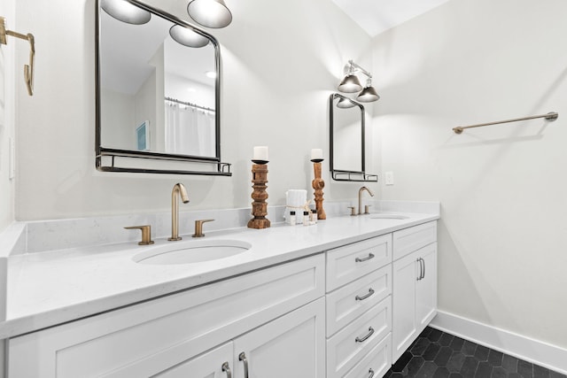 full bathroom featuring double vanity, tile patterned flooring, baseboards, and a sink