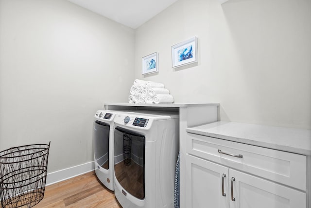 laundry room featuring cabinet space, light wood-style flooring, baseboards, and separate washer and dryer