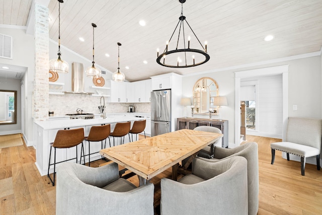 dining space featuring wood ceiling, vaulted ceiling, light wood-style flooring, and crown molding