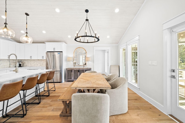 dining area with ornamental molding, vaulted ceiling, light wood-style floors, a chandelier, and recessed lighting