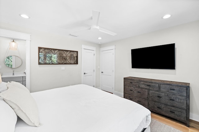 bedroom with light wood finished floors, recessed lighting, a ceiling fan, connected bathroom, and baseboards