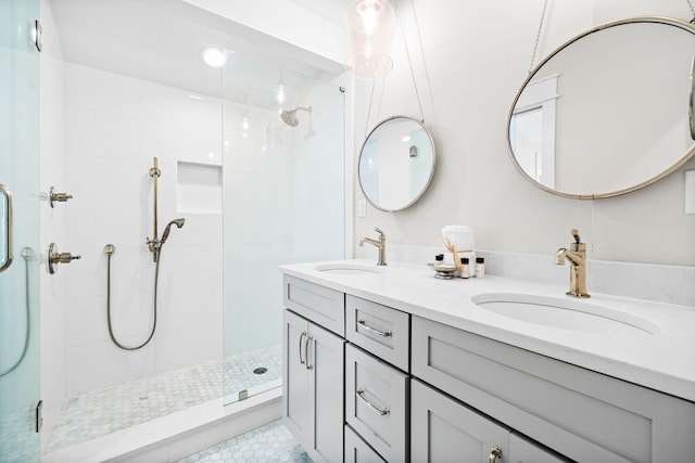 bathroom featuring a stall shower, a sink, and double vanity