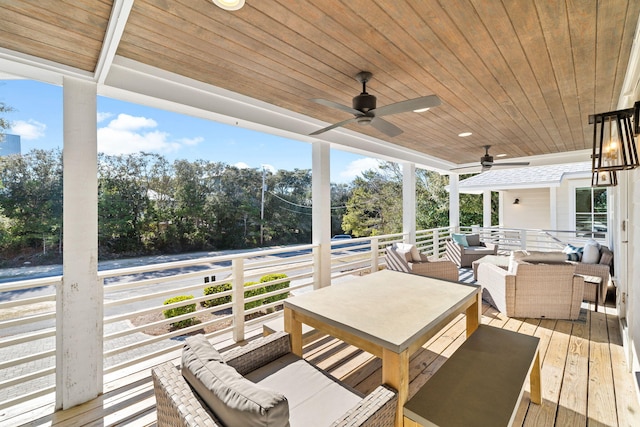 wooden deck with outdoor lounge area and a ceiling fan