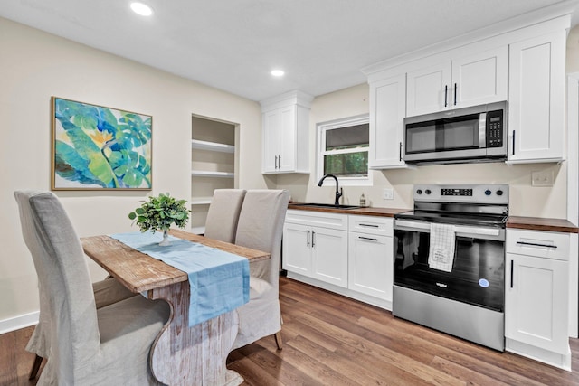 5241 Bob Sikes Rd, Defuniak Springs, FL 32435 - kitchen featuring appliances with stainless steel finishes, a sink, light wood finished floors, white cabinetry, and recessed lighting