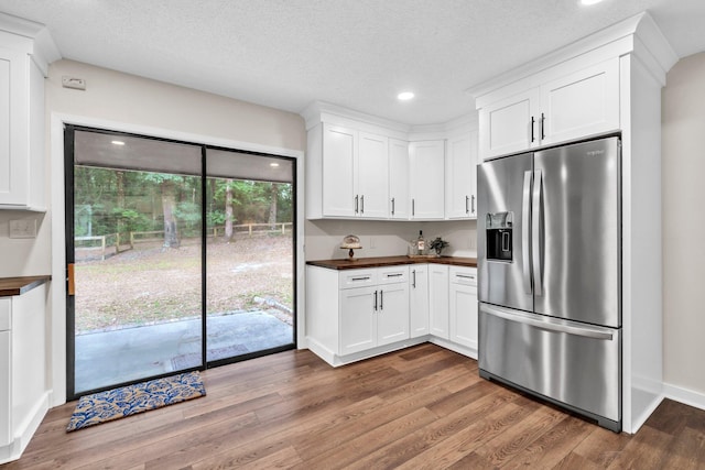 5241 Bob Sikes Rd, Defuniak Springs, FL 32435 - kitchen featuring stainless steel fridge with ice dispenser, wood counters, wood finished floors, white cabinets, and recessed lighting