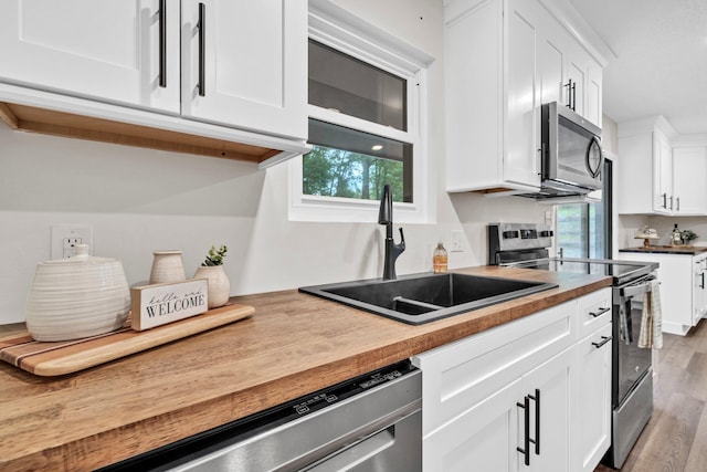 5241 Bob Sikes Rd, Defuniak Springs, FL 32435 - kitchen featuring stainless steel appliances, a sink, white cabinetry, wood finished floors, and butcher block counters