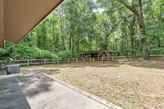 5241 Bob Sikes Rd, Defuniak Springs, FL 32435 - view of yard featuring an outdoor structure, an exterior structure, a wooded view, and central air condition unit