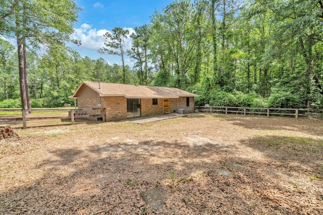 5241 Bob Sikes Rd, Defuniak Springs, FL 32435 - back of house with a patio area, brick siding, and a forest view