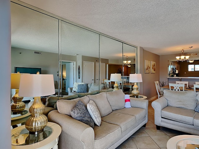 living room featuring light tile patterned floors, visible vents, a textured ceiling, and an inviting chandelier