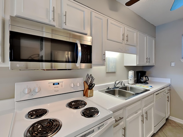 kitchen with white appliances, a sink, a ceiling fan, white cabinets, and light countertops