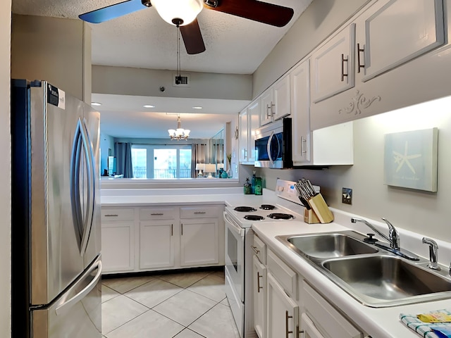 kitchen with light tile patterned floors, white cabinets, stainless steel appliances, light countertops, and a sink