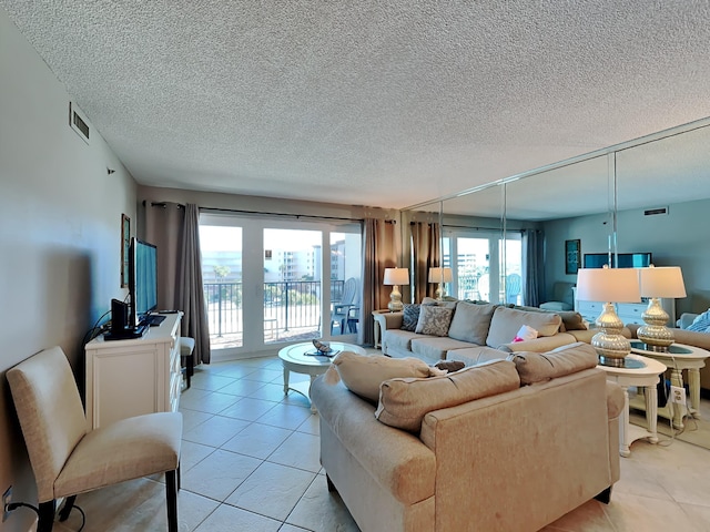 living room featuring visible vents, a textured ceiling, and light tile patterned flooring