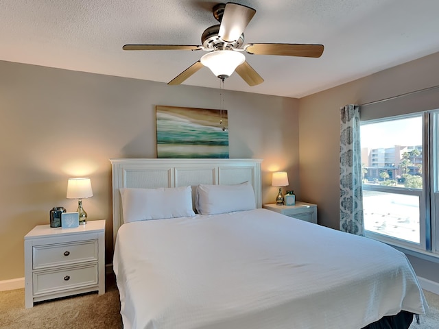 bedroom with carpet floors, ceiling fan, multiple windows, and baseboards