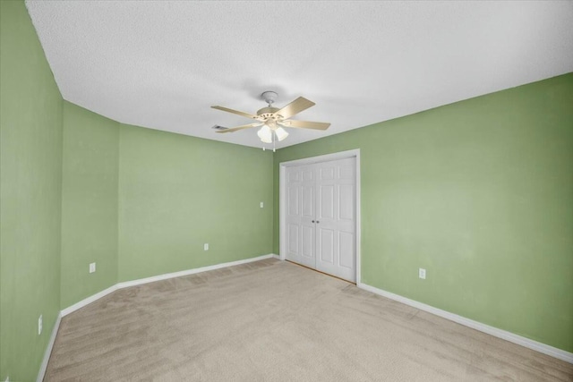 unfurnished bedroom with a ceiling fan, a closet, a textured ceiling, and baseboards