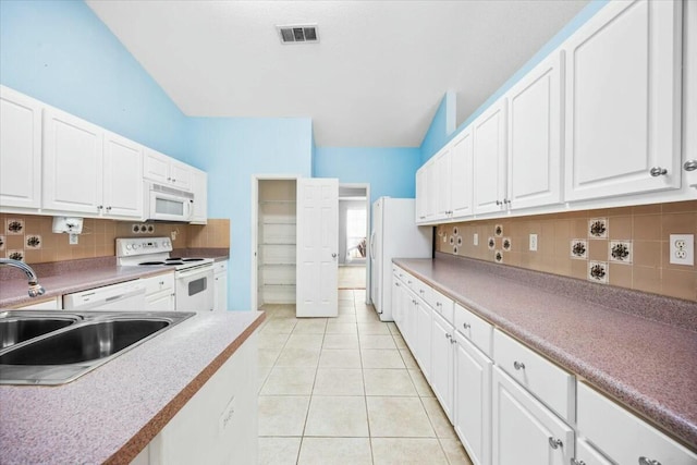 kitchen featuring light tile patterned floors, white appliances, a sink, visible vents, and white cabinetry