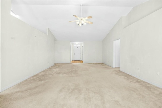 interior space featuring a ceiling fan, lofted ceiling, and light carpet