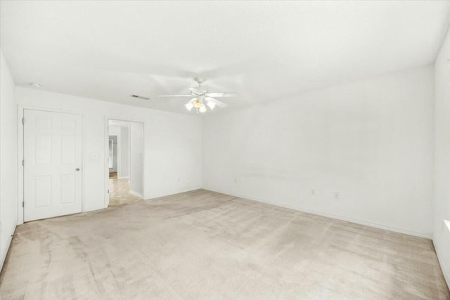 unfurnished room with a ceiling fan, light colored carpet, and visible vents