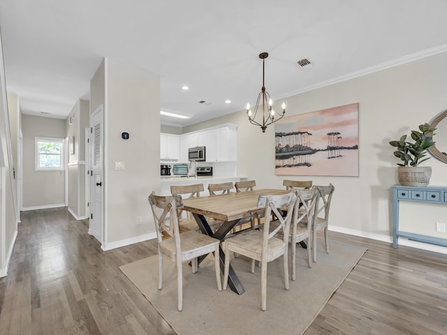 dining space featuring an inviting chandelier, baseboards, and wood finished floors