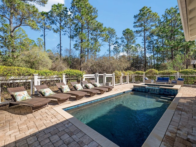 view of pool with a patio, a pool with connected hot tub, and fence