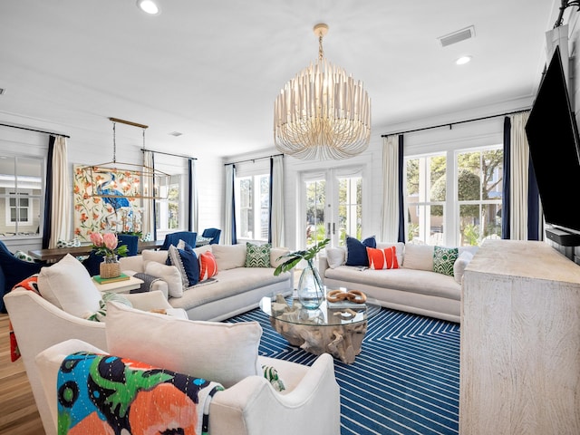 living area with a chandelier, visible vents, and a wealth of natural light