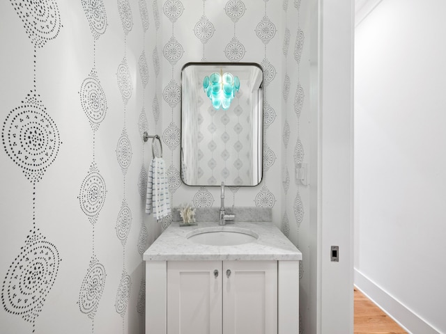 bathroom featuring vanity, baseboards, and wood finished floors