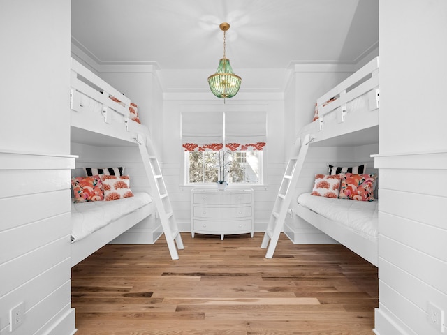 unfurnished bedroom with light wood-style floors and ornamental molding