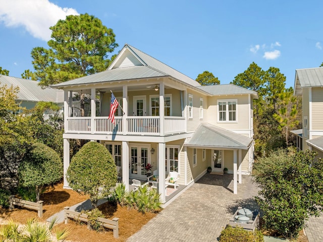 rear view of property featuring french doors, metal roof, decorative driveway, a patio, and a ceiling fan