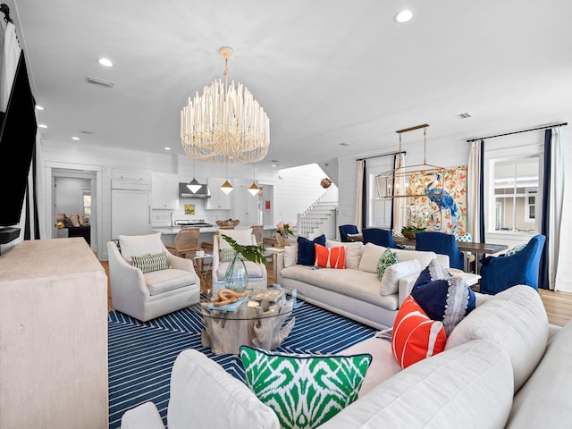 living area with an inviting chandelier, stairway, recessed lighting, and visible vents